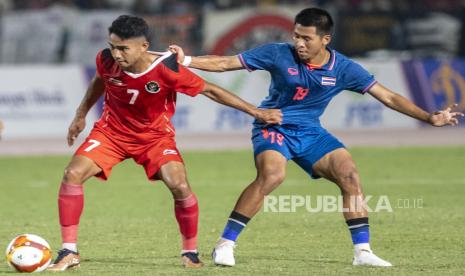 Pesepak bola timnas Indonesia U-22 Marselino Ferdinan yang juga membela klub Belgia KMSK Deinze (kiri) berebut bola dengan pesepak bola timnas Thailand Chayapipat Supunpasuch (kanan) saat pertandingan final Sepak Bola SEA Games 2023 di National Olympic Stadium, Phnom Penh, Kamboja, Selasa (16/5/2023). Indonesia menang 5-2 di laga itu untuk meraih medali emas.