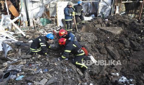 Tim penyelamat Ukraina bekerja di lokasi pasar lokal yang dilanda penembakan di kota Shevchenkove, wilayah Kharkiv, timur laut Ukraina, 09 Januari 2023, di tengah invasi Rusia. Dua orang tewas dan lima lainnya luka-luka, di antaranya seorang anak, akibat serangan roket di desa Shevchenkive di distrik Kupyansk, tulis kepala Administrasi Negara Daerah Kharkiv Oleh Synehubov di telegram. Pasukan Rusia pada 24 Februari 2022, memasuki wilayah Ukraina, memulai konflik yang memicu kehancuran dan krisis kemanusiaan.