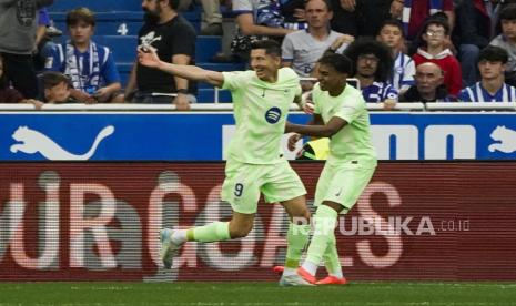 Pemain FC Barcelona Robert Lewandowski melakukan selebrasi seusai mencetak gol ke gawang Alaves pada pertandingan sepak bola LaLiga Spanyol di Vitoria, Spanyol, Ahad (6/10/2024).