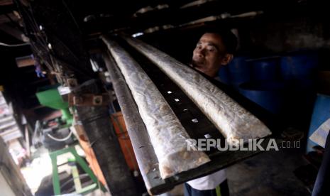 Pengrajin memindahkan tempe buatannya di salah satu Sentra Produksi Tempe, Utan Panjang, Jakarta, Ahad (3/1). Sebagai bentuk protes melonjakanya harga kedelai impor yang mencapai Rp 9.500 per kilogram dari harga normal Rp7.200 per kilogram, Sejumlah produsen tahu dan tempe di Jabodetabek menggelar aksi mogok dagang pada 1 s/d 3 Januari 2021. Mereka meminta pemerintah untuk membuat skema tata niaga kedelai yang saling menguntungkan demi menjaga stabilitas harga untuk kenyamanan pelaku UKM tersebut yang jumlahnya cukup besar.Prayogi/Republika.