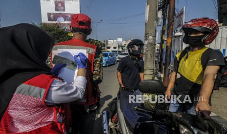 Petugas mencatat identitas pengendara yang tidak memakai masker saat Sosialisasi Gerakan Bermasker di Jalan Raya Margonda, Depok, Jawa Barat, Senin (20/7). Pemerintah Kota Depok melakukan Sosialisasi Gerakan Bermasker menjelang penerapan sanksi denda sebesar Rp 50.000 bagi warga yang tidak menggunakan masker, yang akan diberlakukan mulai Kamis (23/7). Republika/Putra M. Akbar