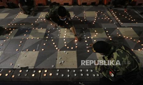 Warga menyalakan lilin saat melakukan aksi di Taman Apsari, Surabaya, Jawa Timur, Selasa (30/3/2021). Aksi itu mengecam tindakan terorisme bom bunuh diri yang terjadi di Gereja Katedral Makassar, Sulawesi Selatan pada Ahad (28/3).