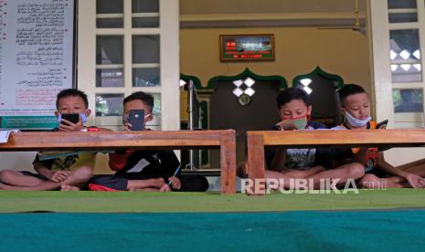 Sejumlah siswa belajar secara daring di serambi masjid At Taqwa Dusun XIV, Borobudur, Magelang, Jawa Tengah, Rabu (29/7/2020). Pihak takmir masjid setempat menyediakan layanan internet gratis khusus untuk pembelajaran daring guna meringankan beban ekonomi warga dalam belanja paket data sekaligus untuk memakmurkan masjid. 