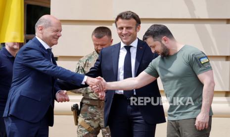 Kanselir Jerman Olaf Scholz, kiri, berjabat tangan dengan Presiden Ukraina Volodymyr Zelenskyy, saat Presiden Prancis Emmanuel Macron, tengah, melihat sebelum pertemuan di Kyiv, Kamis, 16 Juni 2022. 