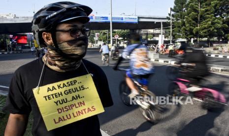 Anggota dari Forum Komunikasi Pesepeda Bandung Raya membawa poster saat Kampanye Tertib Bersepeda di Jalan Ir H Djuanda, Kota Bandung, Ahad (19/7). Kampanye tersebut bertujuan untuk memberikan edukasi keselamatan bersepeda dan tertib berlalu lintas sekaligus sosialisasi pencegahan penyebaran Covid-19 tempat umum. Foto: Abdan Syakura/Republika