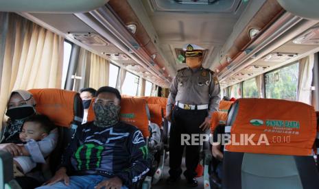 Petugas kepolisian memeriksa jumlah penumpang bus saat dilakukan penerapan Pembatasan Sosial Berskala Besar (PSBB) di perbatasan Tangerang Selatan dengan DKI Jakarta, Jumat (10/4/2020). Dalam operasi penerapan PSBB tersebut petugas kepolisian dan Dishub DKI Jakarta mewajibkan seluruh pengendara dan penumpang menggunakan masker dan pembatasan jumlah penumpang yang akan memasuki Jakarta