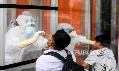  Petugas kesehatan dengan pakaian hazmat mengumpulkan sampel spesimen melakui test swab (ilustrasi)