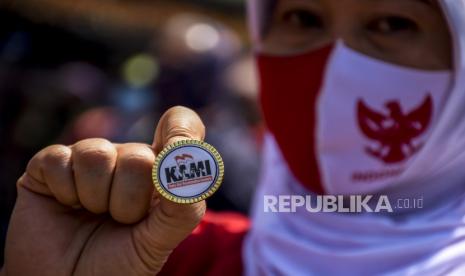 Seorang massa aksi menunjukkan pin Koalisi Aksi Menyelamatkan Indonesia (KAMI) saat aksi dan deklarasi di depan Gedung Sate, Kota Bandung, Senin (7/9). Koalisi Aksi Menyelamatkan Indonesia (KAMI) menggelar deklarasi di sebuah rumah di Kota Bandung dan di depan Gedung Sate setelah sempat mendapat kecaman dan penolakan dari berbagai pihak. Foto: Abdan Syakura/Republika