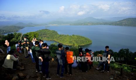 Pengunjung menikmati suasana alam Bukit Bollangi di Desa Timbuseng, Kabupaten Gowa, Sulawesi Selatan, Kamis (11/6/2020). Bukit Bollangi menjadi salah satu destinasi wisata alam yang dikelola oleh warga setempat yang menawarkan keindahan danau, pulau, pegunungan dan sejumlah lokasi untuk berfoto