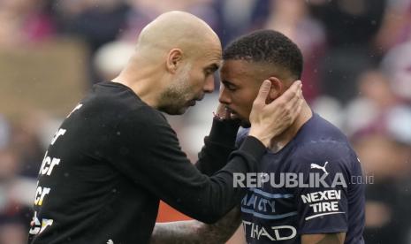  Pelatih kepala Manchester City Pep Guardiola, kiri, berinteraksi dengan pemain Gabriel Jesus pada akhir pertandingan sepak bola Liga Inggris antara West Ham United dan Manchester City di stadion London di London, Ahad, 15 Mei 2022.