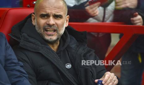 Pelatih kepala Manchester City Pep Guardiola menunggu dimulainya pertandingan sepak bola Liga Premier Inggris antara Nottingham Forest dan Manchester City di City ground di Nottingham, Inggris, Sabtu (18/2/2023). 