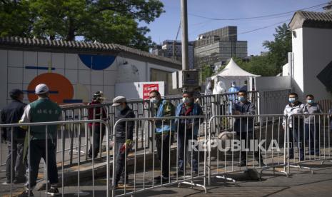  Orang-orang mengantre untuk tes COVID-19 di tempat pengujian setelah pihak berwenang memerintahkan putaran ketiga dari tiga tes virus corona berturut-turut untuk penduduk di distrik Chaoyang, Beijing, Sabtu, 7 Mei 2022. Jalan-jalan di ibu kota China, Beijing terpantau sepi karena publik mengikuti saran pemerintah untuk bekerja dari rumah demi menghentikan penyebaran Covid-19, Jumat (13/5/2022). 