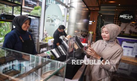 Karyawan melakukan transaksi dengan fitur pembayaran QR Muamalat DIN (MDin) di kedai kopi, Muamalat Tower, Jakarta, Kamis (14/11/2024). 