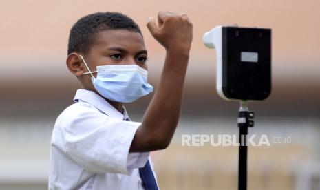 Seorang siswa mengecek suhu tubuh sebelum mengikuti vaksinasi di SD Lentera Kampung Harapan, Kabupaten Jayapura, Papua, Jumat (27/8). Survei singkat yang dilakukan Komisi Perlindungan Anak Indonesia (KPAI) menunjukkan sebanyak 88 persen peserta didik menyatakan kesediaannya untuk divaksinasi.