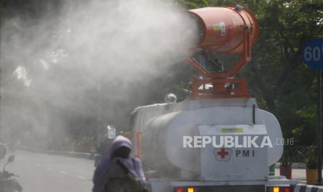 Petugas Palang Merah Indonesia (PMI) menyemprotkan larutan disinfektan di Jalan Kedung Cowek, Surabaya, Jawa Timur, Selasa (2/6/2020). Penyemprotan di sejumlah kawasan itu guna terus menekan penyebaran virus Corona (COVID-19) di Surabaya