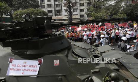  Demonstran berkumpul di dekat jalan di mana tentara dan kendaraan lapis baja dikerahkan selama protes di luar Bank Sentral Myanmar (CBM) di Yangon, Myanmar, 15 Februari 2021. 