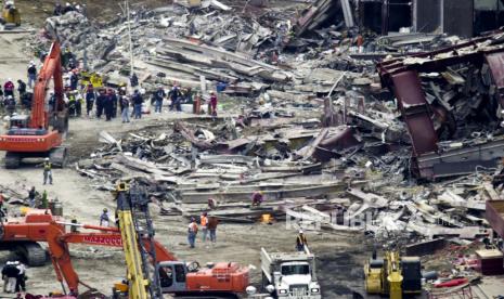  Para pekerja memulai tugas membongkar sisa-sisa World Trade Center yang hancur di New York, New York, AS pada 19 September 2001 (diterbitkan kembali 03 September 2021). Pada tanggal 11 September 2001, selama serangkaian serangan teror terkoordinasi menggunakan pesawat yang dibajak, dua pesawat diterbangkan ke menara kembar World Trade Center yang menyebabkan runtuhnya kedua menara. Pesawat ketiga menargetkan Pentagon dan pesawat keempat menuju Washington, DC akhirnya menabrak sebuah lapangan. Peringatan 20 tahun serangan teroris terburuk di tanah AS akan diperingati pada 11 September 2021.