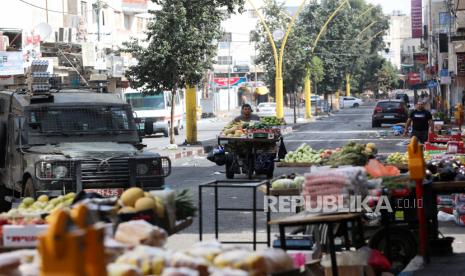  Seorang pedagang kaki lima mengantar gerobaknya ke lokasi bentrokan antara tentara Israel dan pengunjuk rasa Palestina di kota Hebron, Tepi Barat, 12 Oktober 2022. Warga Palestina menyerukan protes dan pemogokan umum di kota-kota Tepi Barat, termasuk Hebron, dalam solidaritas dengan warga Palestina di Kamp Shufat Yerusalem, di mana lebih dari 100.000 orang berada di bawah pengepungan ketat tentara Israel selama empat hari karena penutupan pos pemeriksaan. Warga Palestina Mogok Massal Setelah Tentara Israel Bunuh Udai Tamimi