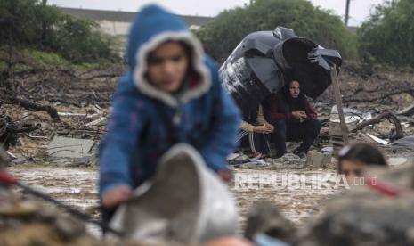 Gadis-gadis Palestina mencari barang-barang mereka di antara puing-puing rumah keluarga mereka yang hancur akibat serangan udara Israel di Deir Al Balah, Jalur Gaza, (29/1/2024).