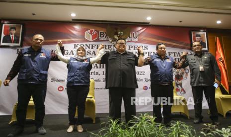 Ketua Bawaslu Rahmat Bagja (tengah) bersama Anggota Bawaslu Totok Hariyono (kiri), Lolly Suhenti (kedua kiri), Puadi (kedua kanan) dan Deputi Bidang Dukungan Teknis Bawaslu La Bayoni (kanan) bergandeng tangan usai memberikan keterangan pers hasil pengawasan pendaftaran dan verifikasi administrasi partai politik calon peserta pemilu 2024 di Jakarta, Senin (15/8/2022). Bawaslu mendapati 275 nama penyelenggara pemilu yang masuk dalam keanggotaan dan kepengurusan partai politik. 