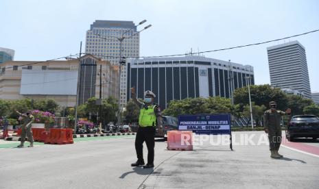 Petugas kepolisian dan Satpol PP berjaga di pos pemeriksaan ganjil-genap di kawasan Bundaran Senayan, Jakarta, Kamis (12/8). Pemprov DKI Jakarta menerapkan sistem ganjil genap di delapan ruas jalan di Jakarta pada pukul 06.00-20.00 WIB untuk mengendalikan mobilitas warga mengikuti perpanjangan PPKM Level 4 hingga 16 Agustus mendatang.