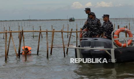 Personel TNI AL bersama warga membongkar pagar laut di Perairan Tanjung Pasir, Kabupaten Tangerang, Banten, Sabtu (18/1/2025).