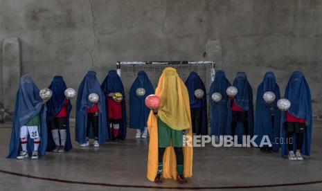 Tim sepak bola wanita Afghanistan berpose untuk foto di Kabul, Afghanistan, Kamis, 22 September 2022. Taliban yang berkuasa telah melarang wanita dari olahraga serta melarang mereka dari sebagian besar sekolah dan banyak bidang pekerjaan. Sejumlah wanita berpose untuk seorang fotografer AP untuk dipotret dengan peralatan olahraga yang mereka sukai. Meskipun mereka tidak harus mengenakan burqa dalam kehidupan sehari-hari, mereka memilih untuk menyembunyikan identitas mereka dengan burqa karena mereka takut pembalasan Taliban dan karena beberapa dari mereka terus berlatih olahraga secara rahasia. Perempuan Afghanistan Melawan! Guru Bentuk Sekolah Rahasia