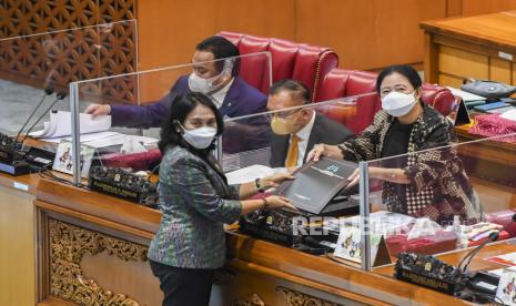 Menteri Pemberdayaan Perempuan dan Perlindungan Anak I Gusti Ayu Bintang Darmawati Puspayoga (kedua kiri) menyerahkan laporan pandangan pemerintah kepada Ketua DPR Puan Maharani (kanan) disaksikan Wakil Ketua DPR Rahmad Gobel (kiri) dan Lodewijk F Paulus kedua kanan) saat Rapat Paripurna DPR RI ke-19 Masa Persidangan IV Tahun Sidang 2021-2022 di Kompleks Parlemen, Jakarta, Selasa (12/4/2022). Dalam rapat paripurna tersebut DPR mengesahkan Rancangan Undang-Undang Tindak Pidana Kekerasan Seksual (RUU TPKS) menjadi undang-undang. 