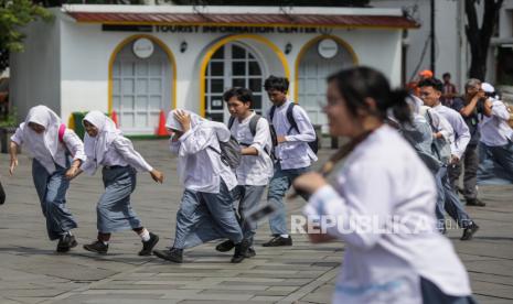 Pelajar berlari sambil menutup kepala saat simulasi tanggap bencana pada peringatan Hari Kesiapsiagaan Bencana (HKB) di Kota Tua, Jakarta, Jumat (26/4/2024). Peringatan HKB 2024 bertemakan Siap Untuk Selamat tersebut memberikan edukasi dan menampilkan peralatan yang digunakan untuk penanggulangan bencana kepada masyarakat.