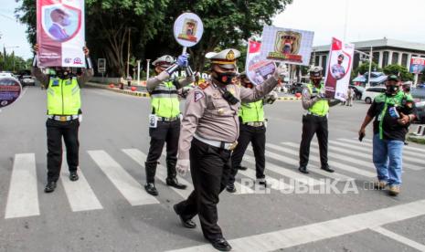 Personel Polri Satuan Lalu Lintas memegang alat peraga saat kampanye protokol Kesehatan COVID-19 di pusat Kota Lhokseumawe, Aceh, Kamis (10/9/2020). Kampanye yang digencarkan gabungan TNI-Polri itu diharapkan dapat meningkatkan kesadaran akan pentingnya memakai masker dan mematuhi protokol kesehatan untuk mencegah penyebaran COVID-19. 