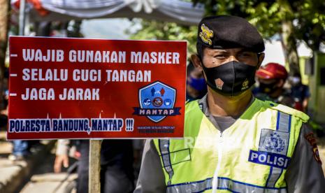 Anggota Polresta Bandung membawa poster saat sosialisasi protokol kesehatan di area Kantor KPU Kabupaten Bandung, Jalan Sindang Wargi, Soreang, Kabupaten Bandung, Jumat (4/9). Sosialisasi tersebut bertujuan untuk mengajak masyarakat agar disiplin menerapkan protokol kesehatan dalam semua tahapan Pilkada serentak tahun 2020 guna meminimalisir penyebaran Covid-19. Foto: Abdan Syakura/Republika