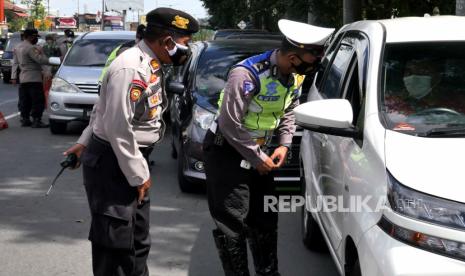 Petugas Polres Klaten memeriksa kartu vaksinasi pengendara saat operasi yustisi PPKM Darurat di Prambanan, Klaten, Jawa Tengah, Selasa (6/7). Petugas gabungan Polri dan TNI menggelar operasi penyekatan untuk mendukung PPKM Darurat dalam rangka menekan penyebaran Covid-19.