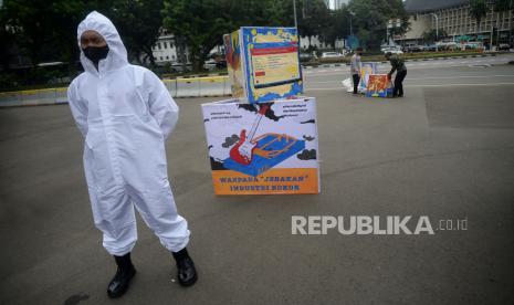 Polisi berjaga ketika massa dari Koalisi Masyarakat Peduli Kesehatan (KOMPAK) melakukan aksi kreatif parade mural hari kesehatan Nasional di Kawasan Taman Patung Kuda, Jakarta, Rabu (17/11). Aksi tersebut merupakan bentuk komitmen untuk terus mendorong pemerintah membuat kebijakan yang lebih kuat guna melindungi kesehatan masyarakat khususnya anak dan remaja dari dampak rokok yang berbahaya.Prayogi/Republika