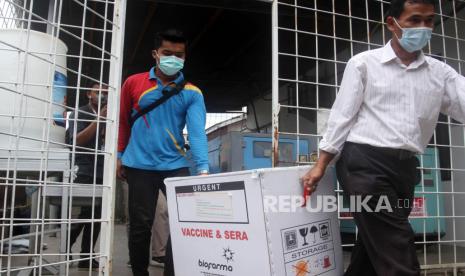 Petugas mengangkat dus berisi vaksin COVID-19 yang akan didistribusikan di Dinas Kesehatan Provinsi Sumatera Barat, Padang, Rabu (13/1/2021). Dinas Kesehatan Provinsi Sumatera Barat mulai mendistribusikan vaksin COVID-19 Sinovac ke dua daerah penerima vaksin tahap I yaitu Kota Padang sebanyak 18.680 dosis dan Kabupaten Pesisir Selatan sebanyak 3.640 dosis.  