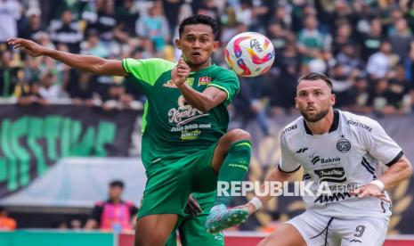 Pesepak bola Persebaya Surabaya Arief Catur Pamungkas (kiri) berebut bola dengan pesepak bola Persija Jakarta Marko Simic (kanan) saat pertandingan BRI Liga 1 di Stadion Gelora Bung Tomo, Surabaya, Jawa Timur, Jumat (22/11/2024). Persebaya mengalahkan Persija Jakarta dengan skor 2-1. 