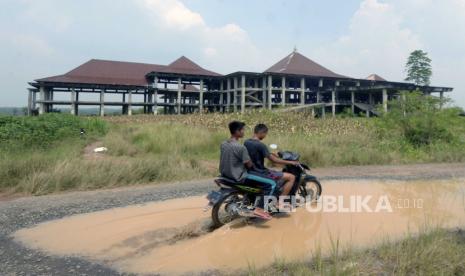 Perbaiki Jalan Rusak di Lampung, Jokowi: Jangan Semuanya Pemerintah Pusat. Foto: Pengendara motor melintas di antara jalan berlubang yang tergenang air di jalan terusan Ryacudu Jati Agung, Lampung Selatan Lampung, Rabu (3/5/2023). Sejumlah titik jalur akses menuju Kota Baru Lampung, mengalami kerusakan sehingga membahayakan kesalamatan pengendara yang nelintas jalur tersebut. 