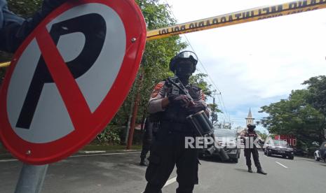 Petugas kepolisian berjaga di lokasi dugaan bom bunuh diri di depan Gereja Katedral Makassar, Sulawesi Selatan, Minggu (28/3/2021). 