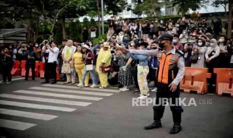 Petugas Dinas Perhubungan (Dishub) mengatur lalu lintas di area zebra cross yang dijadikan lokasi peragaan busana Citayam Fashion Week di kawasan Dukuh Atas, Jakarta, Rabu (27/7/2022). Sejumlah petugas gabungan dari Dishub dan Satpol PP melakukan penjagaan dan normalisasi fungsi zebra cross untuk penyeberangan serta perlintasan kendaraan motordan mobil. Meski demikian, kegiatan fashion show jalanan tersebut masih tetap berlangsung dengan imbauan untuk menjaga ketertiban agar tidak terjadi kemacetan. Republika/Thoudy Badai