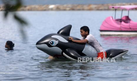 Wisata Pantai di Lampung Selatan Tutup Selama Libur Lebaran. Seorang anak berenang menggunakan pelampung mainan di tengah pandemi COVID-19 di pantai Ule Lhuee, Aceh, Jumat (30/10/2020). Pariwisata menjadi sektor yang paling menderita kerugian akibat pembatasan perjalanan oleh semua negara di dunia akibat pandemi virus corona. Indonesia telah kehilangan sekitar Rp 85 triliun (5,87 miliar dolar AS) pendapatan pariwisata sepanjang tahun ini.