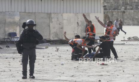  Petugas medis merawat seorang pria yang terluka selama bentrokan dengan pasukan keamanan Israel di kompleks Masjid Al Aqsa di Kota Tua Yerusalem Senin, 10 Mei 2021.