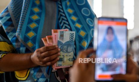 Warga menerima bantuan sosial program keluarga harapan (PKH) di Kantor Pos Cabang Utama, Bandung, Jawa Barat, Jumat (10/5/2024). Pemerintah melalui Kementerian Sosial serta bekerjasama dengan PT Pos Indonesia menyalurkan bantuan sosial PKH kepada 23.000 keluarga penerima manfaat di Kota Bandung yang bertujuan mengurangi kemiskinan dan meningkatkan kualitas hidup masyarakat. 