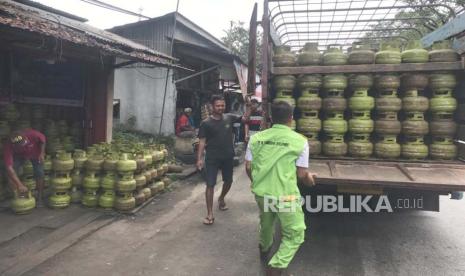 Petugas mengangkut gas LPG 3 kilogram.