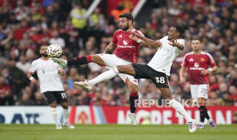 Pemain Manchester United Bruno Fernandes (kiri) berduel dengan pemain Liverpool Ryan Gravenberch (kanan) saat bertanding pada pekan ketiga Premier League 2024/2025 di stadion Old Trafford, Ahad (1/9/2024).