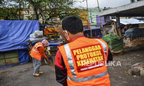 Warga yang terjaring razia melanggar protokol kesehatan (prokes) menjalani sanksi sosial menyapu dan membersihkan sampah saat operasi yustisi di Pasar Cikurubuk, Kota Tasikmalaya, Jawa Barat, Senin (28/9/2020). Pemerintah Kota Tasikmalaya membentuk Tim Penindak Pelanggaran Prokes terdiri dari TNI, Polri, BPBD, Satpol PP, Dishub dan Dinkes dengan memberikan teguran tegas berupa bayar denda dan sanksi sosial kepada pelanggar berdasarkan Instruksi Presiden Nomor 6 tahun 2020 tentang peningkatan disiplin dan penegakan hukum protokol kesehatan dalam pencegahan dan pengendalian COVID-19. 