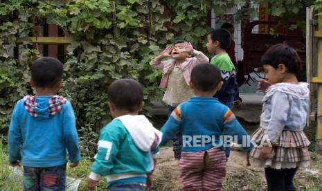 Anak-anak Uighur bermain di luar ruangan di Hotan, Xinjiang, China. Associated Press telah menemukan bahwa pemerintah Cina sedang melaksanakan program pengendalian kelahiran yang ditujukan untuk warga Uighur, Kazakh, dan minoritas Muslim lainnya di Xinjiang, bahkan ketika sebagian besar penduduk Han di negara itu didorong untuk memiliki lebih banyak anak. (AP Photo/Ng Han Guan)