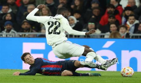 Striker Barcelona Gabi (kiri) berduel dengan bek Real Madrid Antonio Rudiger (kanan) pada laga semifinal leg pertama Copa del Rey antara Real Madrid melawan Barcelona di Santiago Bernabeu, Jumat (3/3/2023) dini hari WIB.