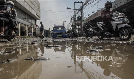 Pengendara melintasi jalan penghubung antara Kabupaten Bogor dan Kota Depok yang rusak di Pabuaran, Kabupaten Bogor, Jawa Barat, Jumat (6/8/2021).  Jalan rusak serta berlubang tersebut dapat membahayakan keselamatan para pengguna jalan yang melintas, dan sudah berbulan-bulan tidak kunjung diperbaiki oleh Pemerintah setempat. 