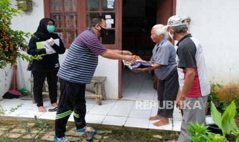 Petugas Jaring Pengaman Sosial (JPS) swadaya tingkat desa memberikan bantuan sembako kepada warga terdampak COVID-19 di Perumahan Candi Asri, Kedu, Temanggung, Jawa Tengah, Rabu (8/4/2020). Warga setempat secara swadaya melakukan iuran yang hasilnya disumbangkan kepada warga terdampak COVID-19 berupa sembako dan hand sanitizer