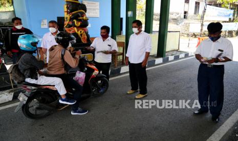 Wisatawan membayar tiket masuk di pos retribusi gerbang masuk Pantai Parangtritis, Yogyakarta, Rabu (20/10). Pantai di Kabupaten Bantul mulai dibuka kembali seiring turun status PPKM menjadi level 2. Selain wajib menggunakan masker, pengunjung yang masuk diukur suhu tubuhnya diboos retribusi.