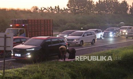 Pemudik melakukan shalat shubuh saat diberlakukan sistem satu arah Tol Cipali Km 141, Indramayu, Jawa Barat, Jumat (6/5/2022). Kepolisian memberlakukan //one way// arus balik secara dinamis dan melihat situasi kepadatan arus kendaraan pemudik.  Foto: Tahta Aidilla/Republika.